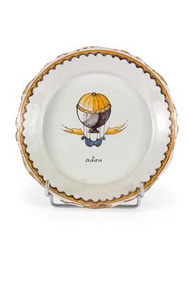 une assiette décorée d'un oiseau, posée sur un socle