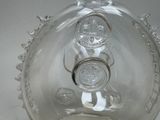 a clear glass vase with a silver lid on a table