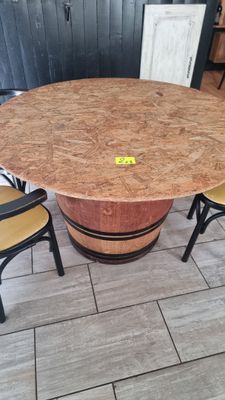 une table fabriquée à partir d'un tonneau de vin, entourée de chaises
