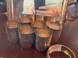 une théière et des tasses en argent posées sur une table avec un miroir