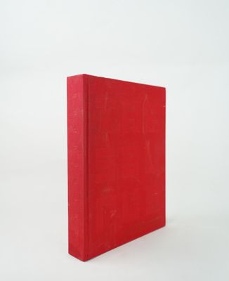 the red book is sitting on a white surface with a white background