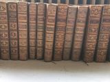 Plusieurs vieux livres sont alignés sur une étagère devant un radiateur