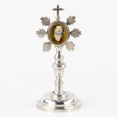 an image of a silver cross with a picture of a man on it