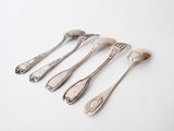 six silverware spoons and a fork on a white surface