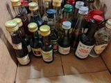 many bottles of alcohol in a cardboard box on the floor