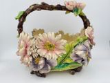un petit panier orné de fleurs, posé sur une surface blanche
