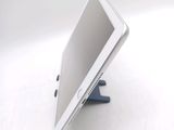 a tablet computer sitting on a stand on a white surface