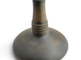 a metal vase that is sitting on a white surface