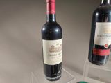 two bottles of wine and a glass of wine on a table