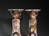 pair of vases with floral designs on them against a black background