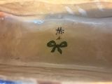 a white vase with a green bow on it