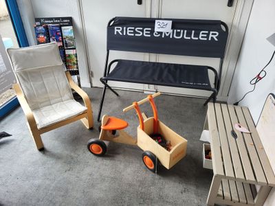 deux chaises et un banc dans une pièce où est accrochée une pancarte au mur
