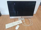 a computer monitor, keyboard and mouse on a wooden floor