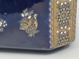 a blue and gold box with a bird design on it