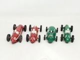 four toy cars that are lined up on a white surface