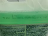 a bottle of green liquid sitting on a counter