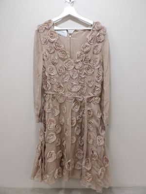 une robe beige suspendue à un cintre dans une pièce