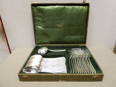 un coffret vert contenant de l'argenterie sur une table