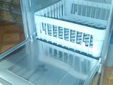 an open refrigerator with a basket in it on the floor