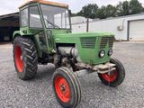 un tracteur vert garé sur un parking