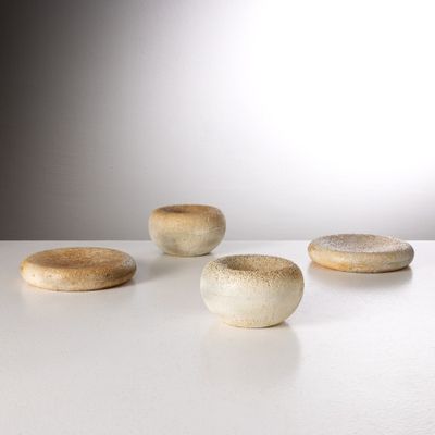 cinq pierres posées sur une table blanche, avec une source de lumière en arrière-plan