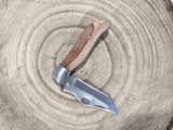 a knife that is laying on top of a piece of wood
