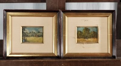 two framed paintings of a landscape on a shelf in front of a mirror