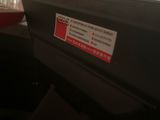 a close up of a black box with a red sticker on it