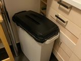 a trash can in the corner of a kitchen next to a step stool
