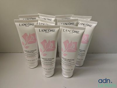 four tubes of lancome hand cream sitting on a table