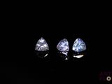 three trillion cut diamonds in the dark with a reflection on the ground
