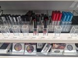 a display case with lipstick and other cosmetics items in it