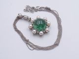 collier composé d'une pierre verte entourée de perles, monté sur une chaîne en argent
