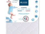 un gros plan d'un bébé allongé sur le matelas de son lit bébé