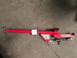 a red pipe cutter laying on the ground next to a black chair