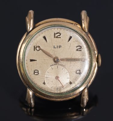 a gold clock that is sitting on a black surface