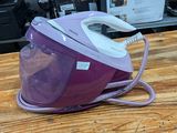 purple and white steam iron sitting on top of a wooden table