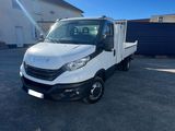 un camion blanc garé sur un parking à côté d'un immeuble