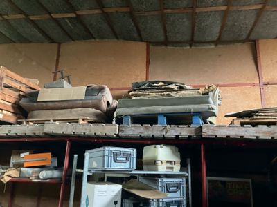a pile of luggage sitting on top of a shelf in a garage