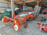 un tracteur garé dans une grange avec d'autres machines agricoles