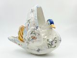 un oiseau en céramique posé sur une surface blanche