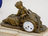 a statue of a woman sitting on top of a clock