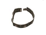 Le bracelet est en métal et présente un motif très travaillé.