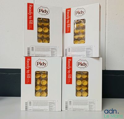 trois boîtes de cornichons marinés posées sur un comptoir