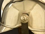 a close up of a silver helmet with a medallion on it