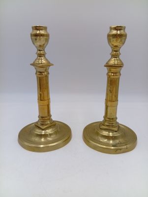 paire de chandeliers anciens en laiton sur fond blanc