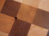a wooden cutting board with a checkered pattern on it