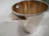 une coupe en argent avec une cuillère posée sur une table