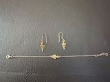 two pairs of earrings and a bracelet on a black surface