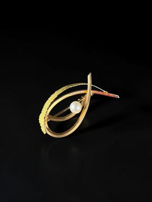 a close up of a gold ring with a pearl in it